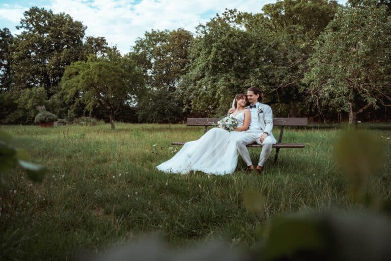 00015-florian-knusper-hochzeitsfotograf-wuerzburg-brautpaar-auf-bank-im-garten-Vogelsburg Volkach