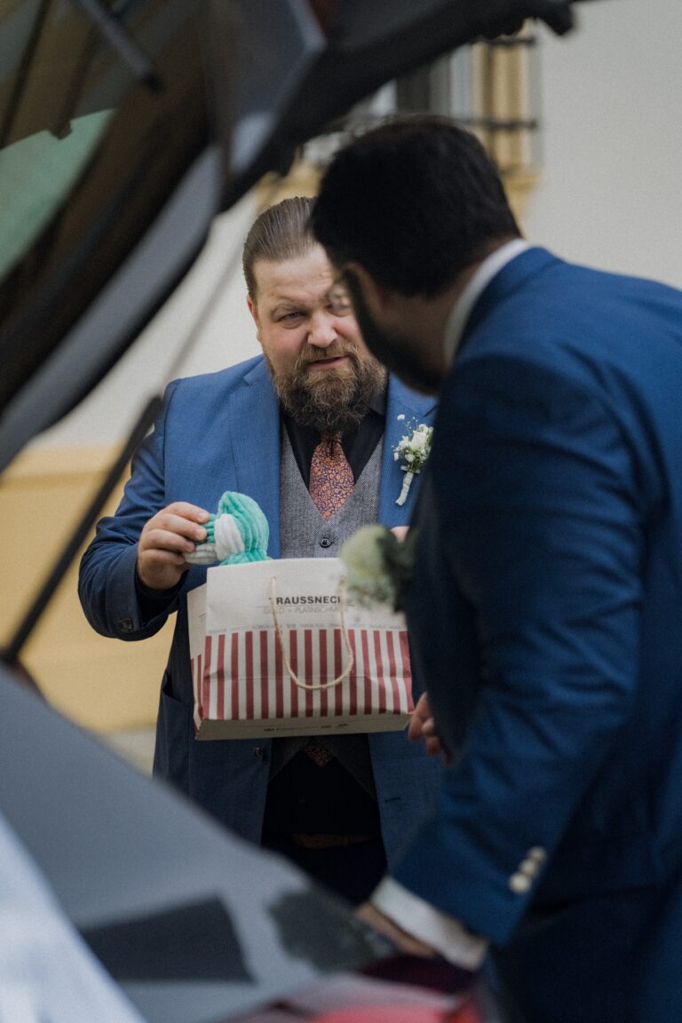 00017-florian-knusper-hochzeitsfotograf-wuerzburg-herr-im-anzug-mit-geschenk-Schloss Oberschwarzach