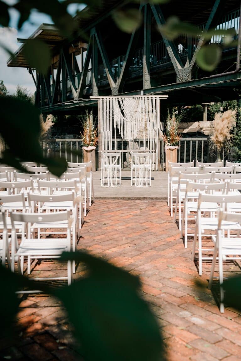 00023-florian-knusper-hochzeitsfotograf-wuerzburg-stuhlreihe-im-freien-Brückenbaron