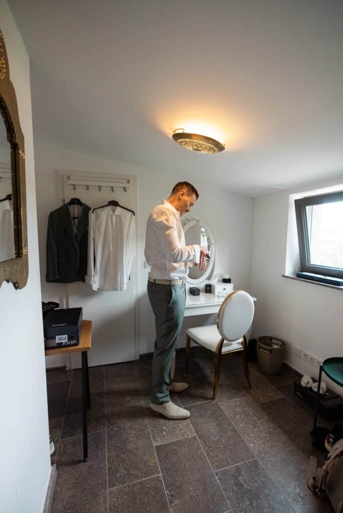 Bräutigam zieht sich im Ankleidezimmer an