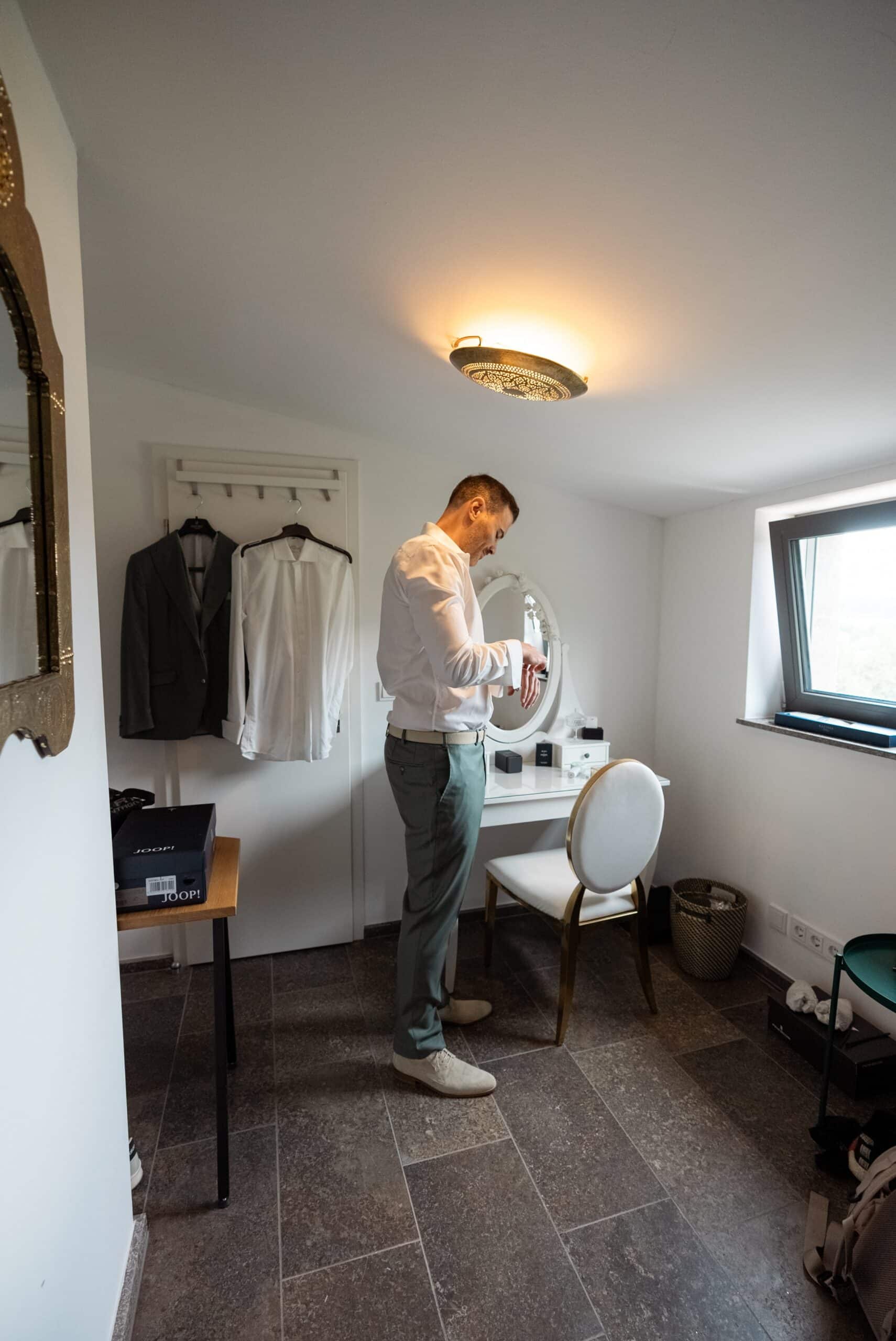 Bräutigam zieht sich im Ankleidezimmer an
