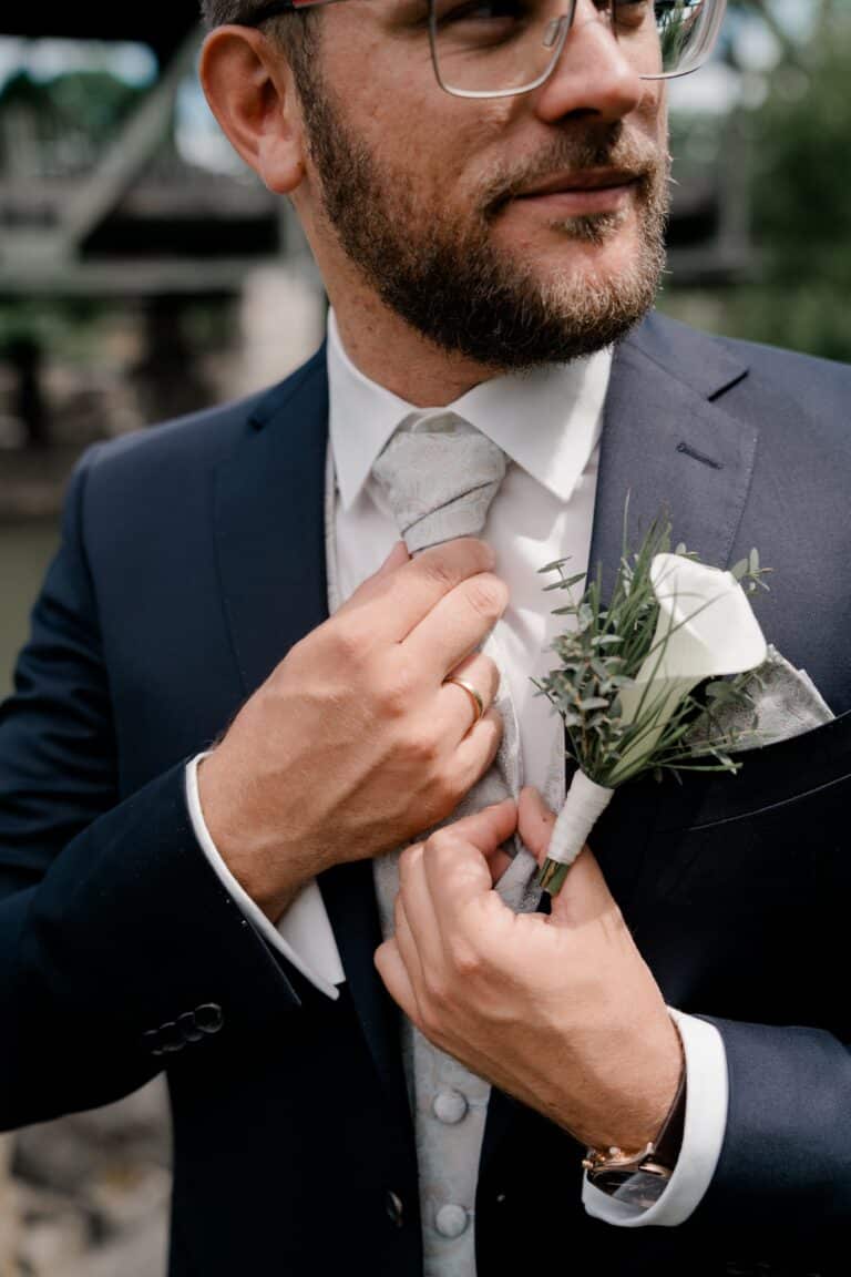 00058-florian-knusper-hochzeitsfotograf-wuerzburg-anzug-mit-ansteckblume-Brückenbaron
