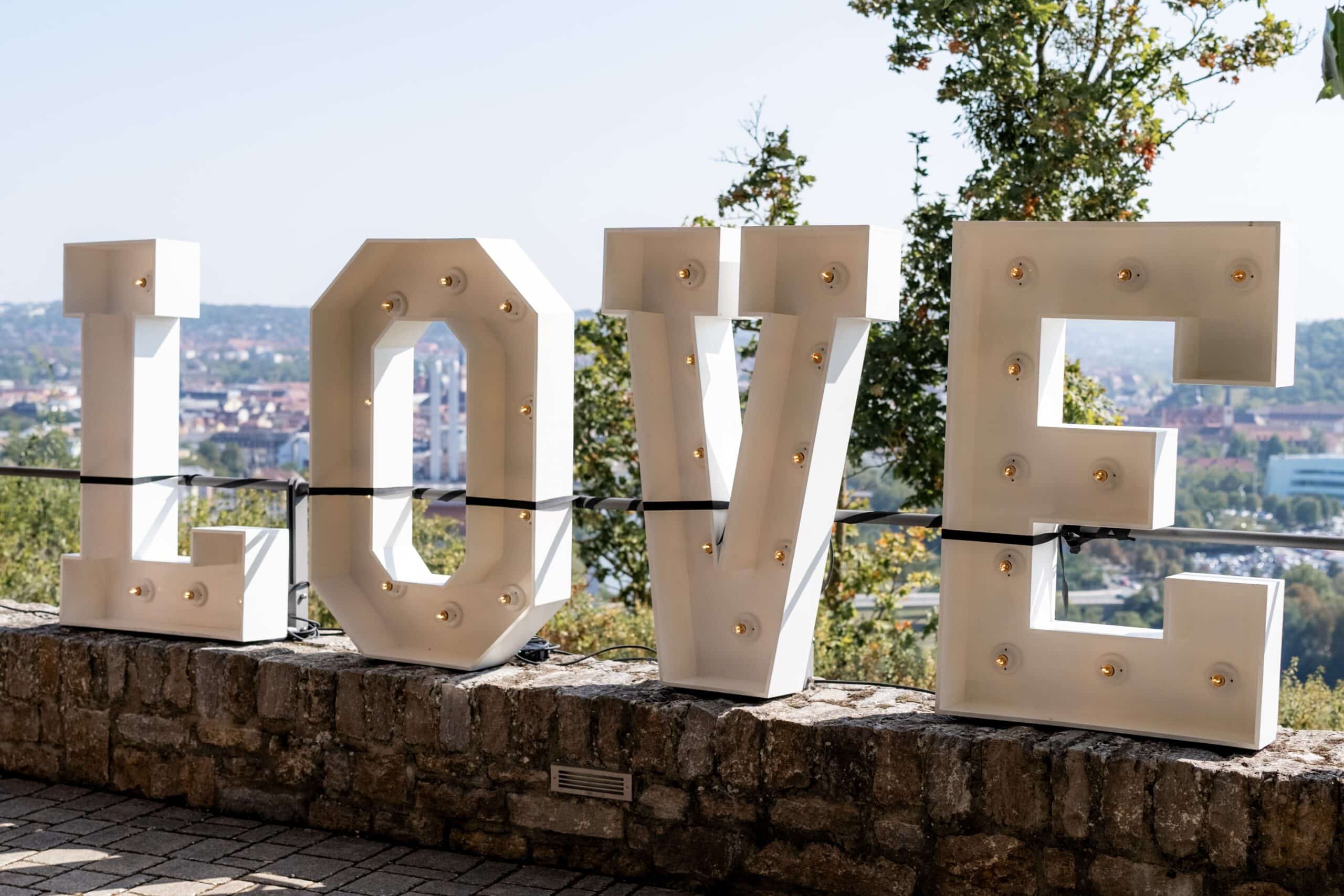 Leuchtbuchstaben LOVE im Freien auf Mauer
