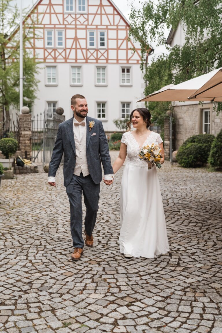 00069-florian-knusper-hochzeitsfotograf-wuerzburg-brautpaar-auf-pflastersteinen-Winzerhof Stahl