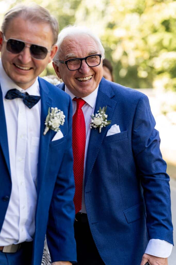 Gäste in eleganter Kleidung im Garten feiern