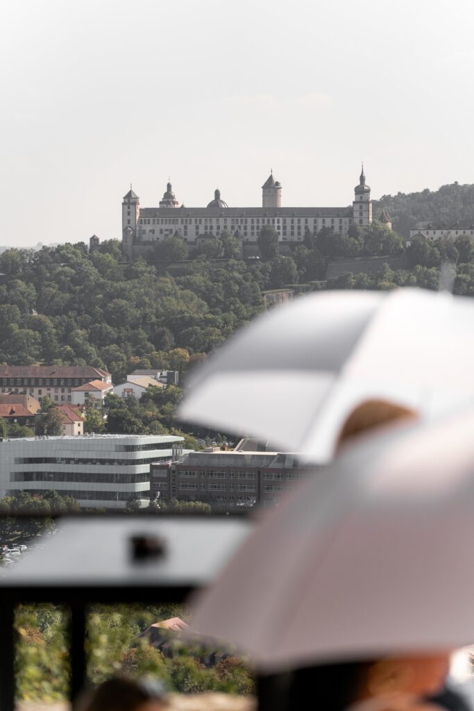 Schlossblick mit Gästen unter weißen Schirmen