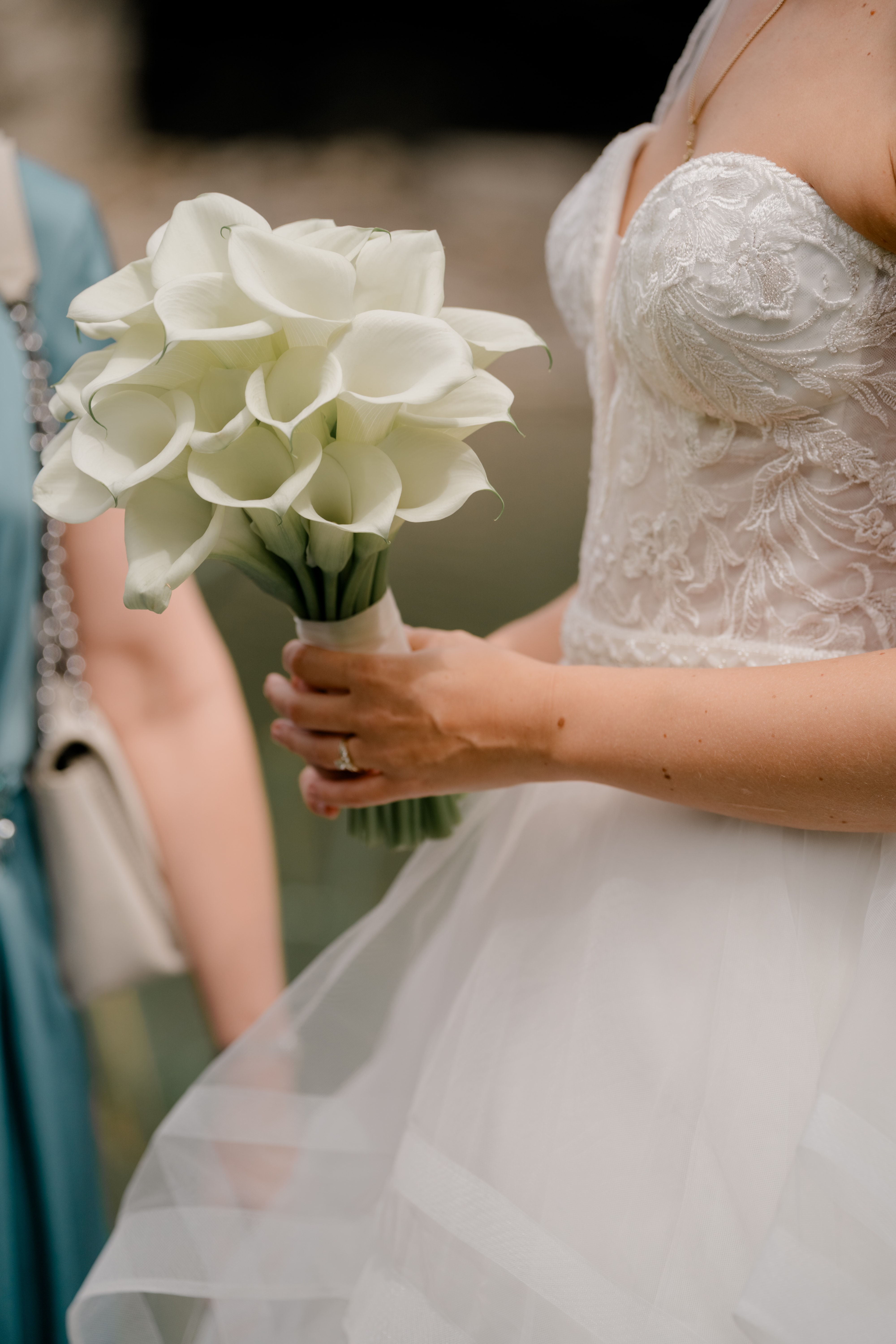 Brautstrauß mit weißen Blumen und Spitzenkleid