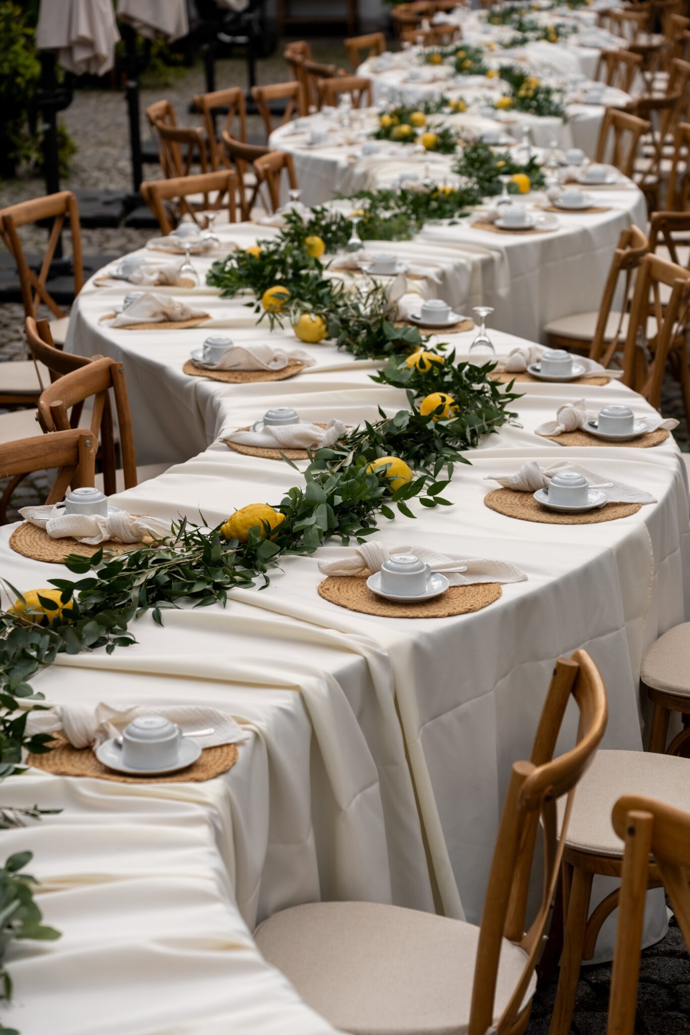 Lange Tafel mit weißer Decke, Grün und Zitronen im Freien