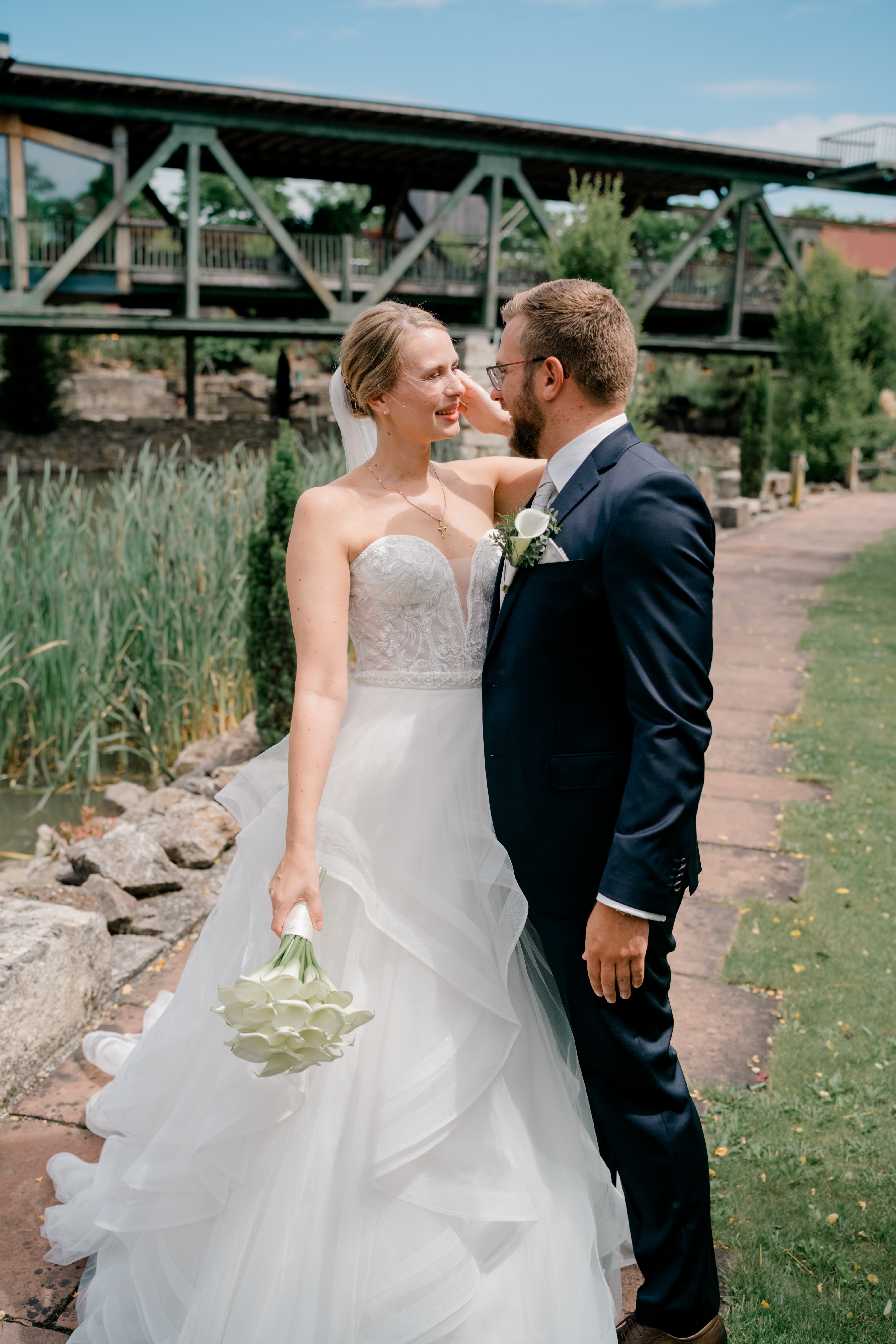 Brautpaar im Garten vor Holzbrücke