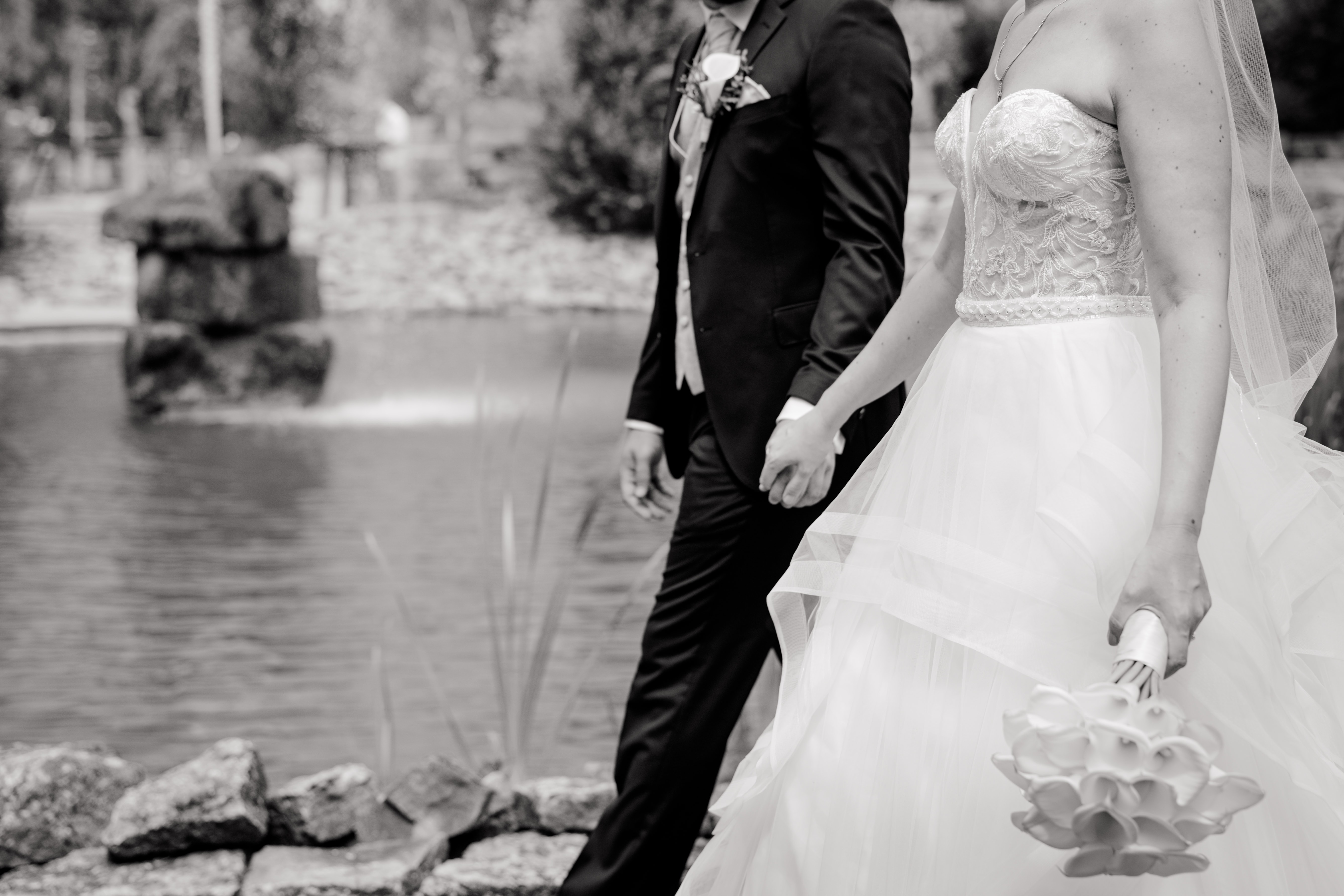 Brautpaar spaziert am Seeufer entlang‍