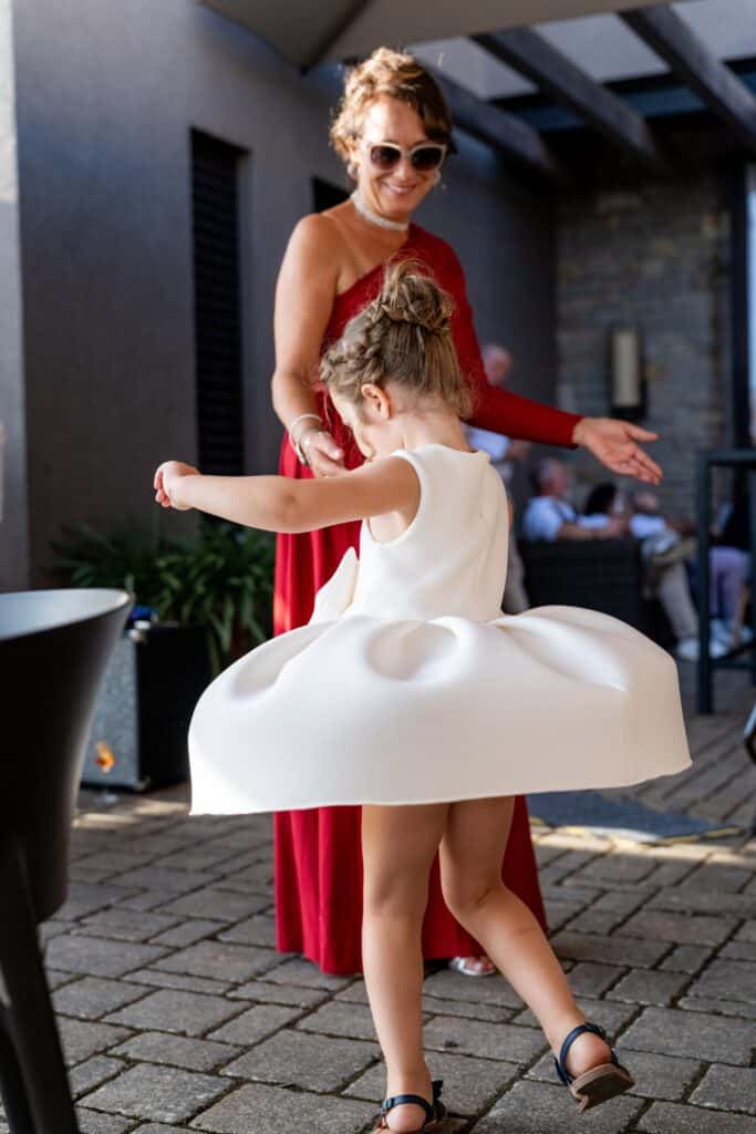 Kind in elegantem Kleid tanzt bei Hochzeit