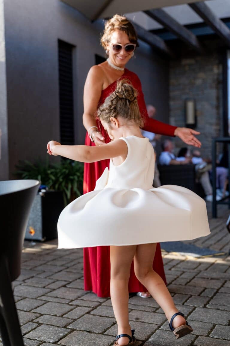 00109-florian-knusper-hochzeitsfotograf-wuerzburg-tanzendes-kind-mit-kleid-Schlosshotel Steinburg Wuerzburg