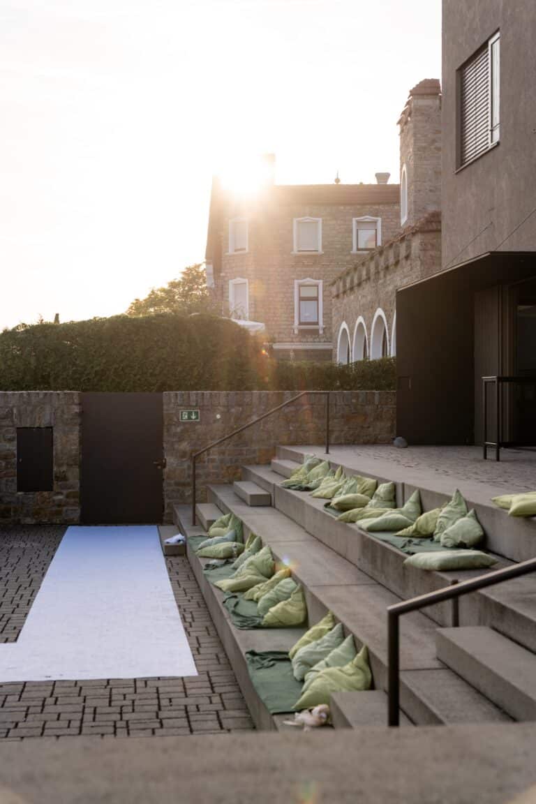 00116-florian-knusper-hochzeitsfotograf-wuerzburg-sitzkissen-auf-stufen-Schlosshotel Steinburg Wuerzburg