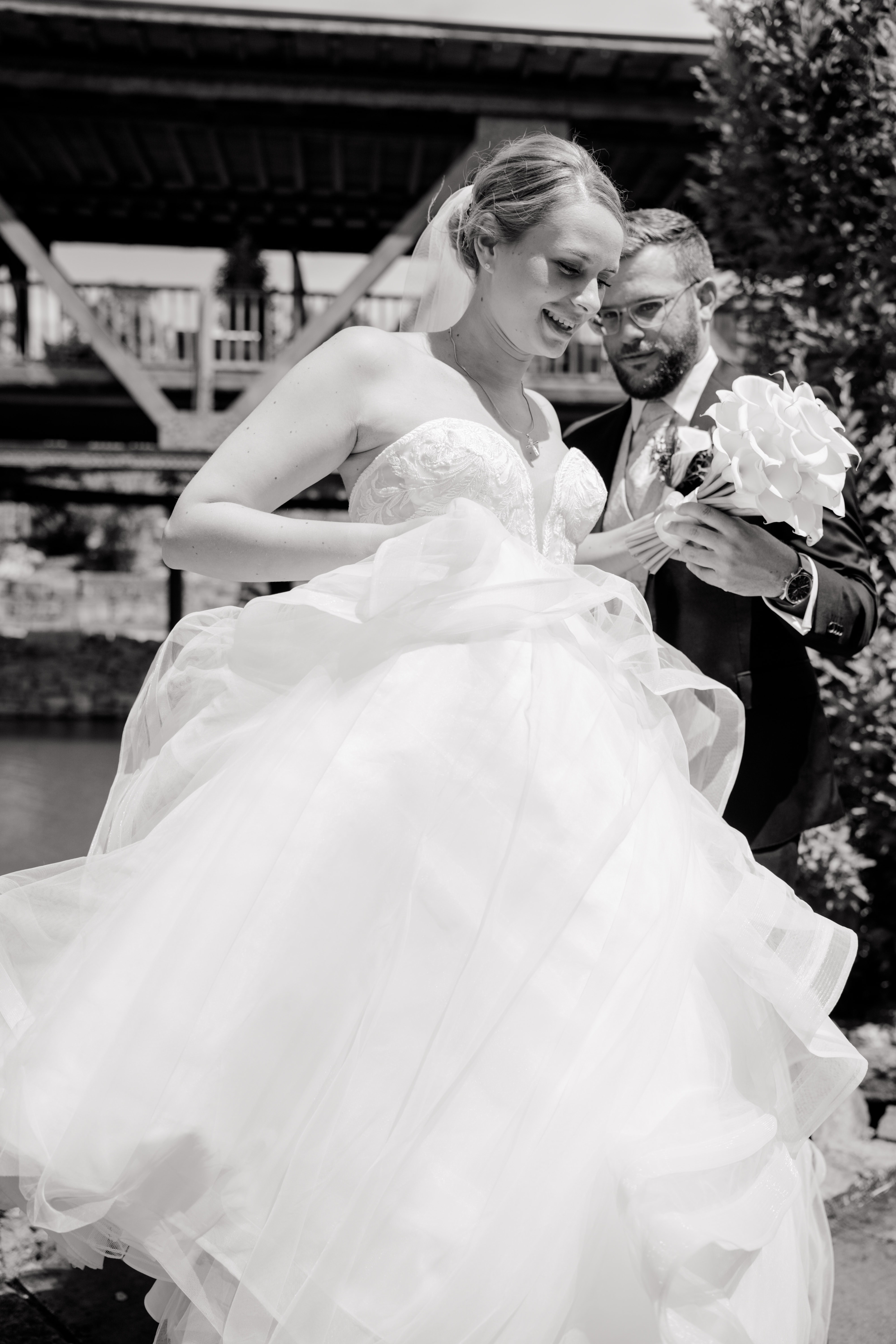 Brautpaar mit Blumenstrauß vor Holzkulisse