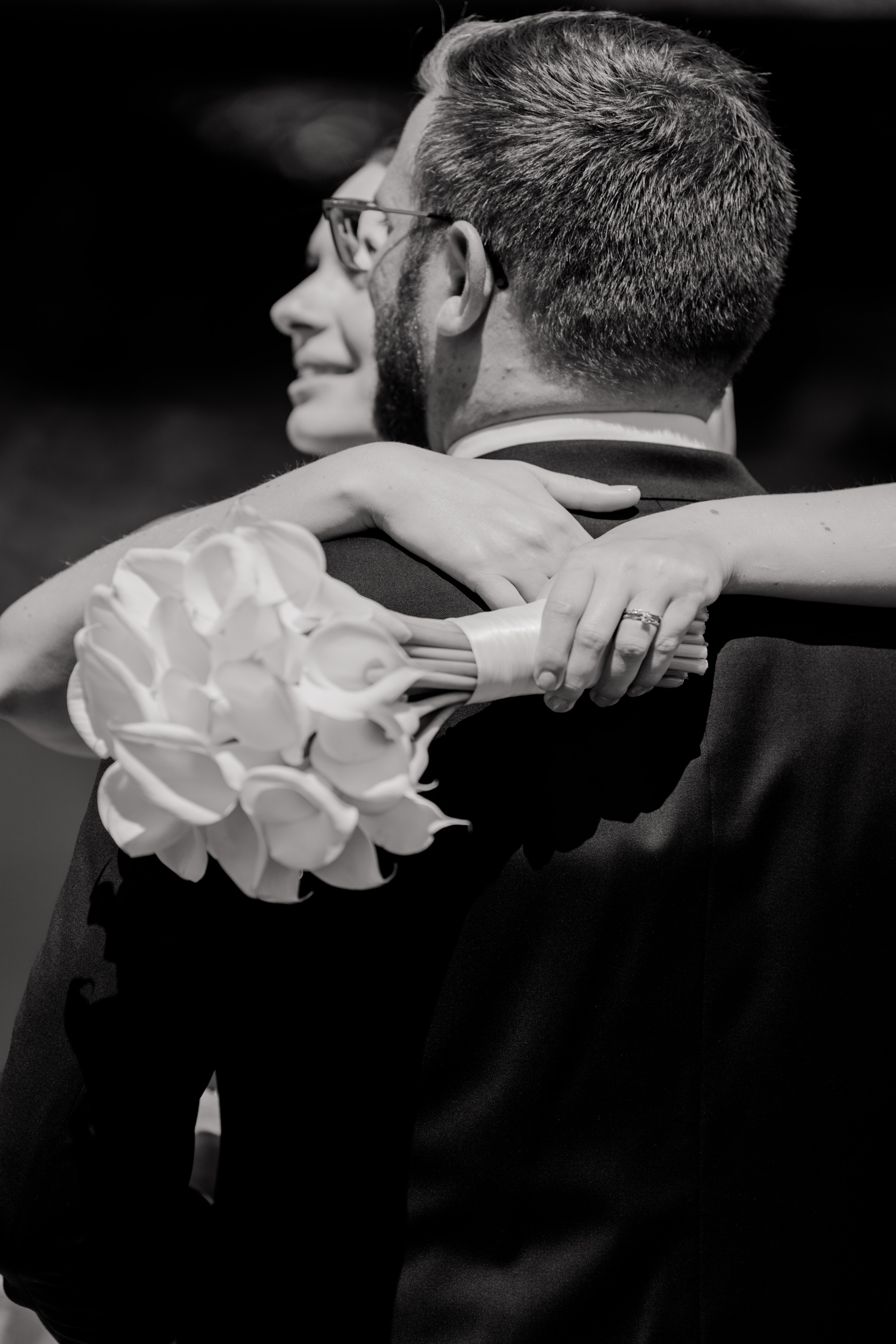 Brautpaar umarmt mit Blumenstrauß