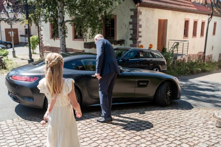 00146-florian-knusper-hochzeitsfotograf-wuerzburg-kind-und-mann-am-auto-Kloster Bronnbach