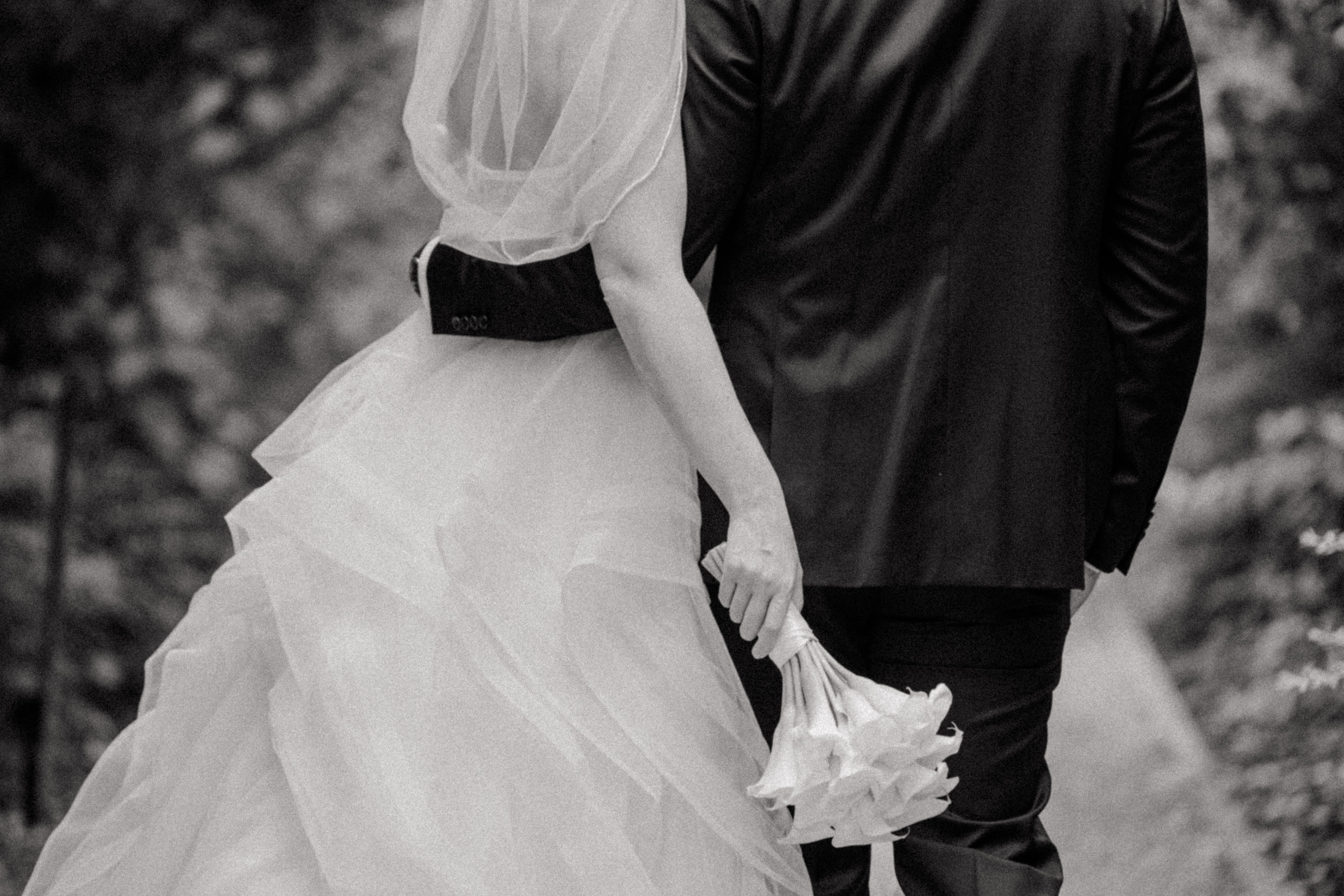 Brautpaar von hinten auf Waldweg