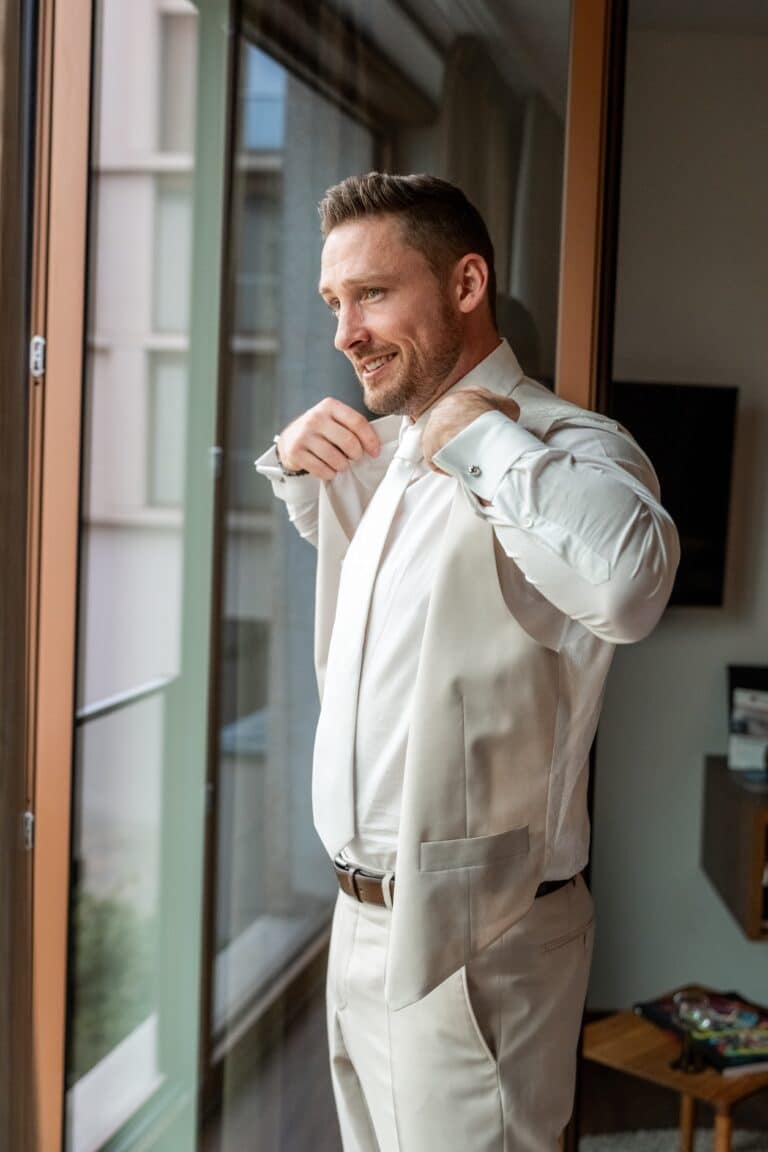 00232-florian-knusper-hochzeitsfotograf-wuerzburg-mann-im-anzug-am-fenster-Villa Oriental