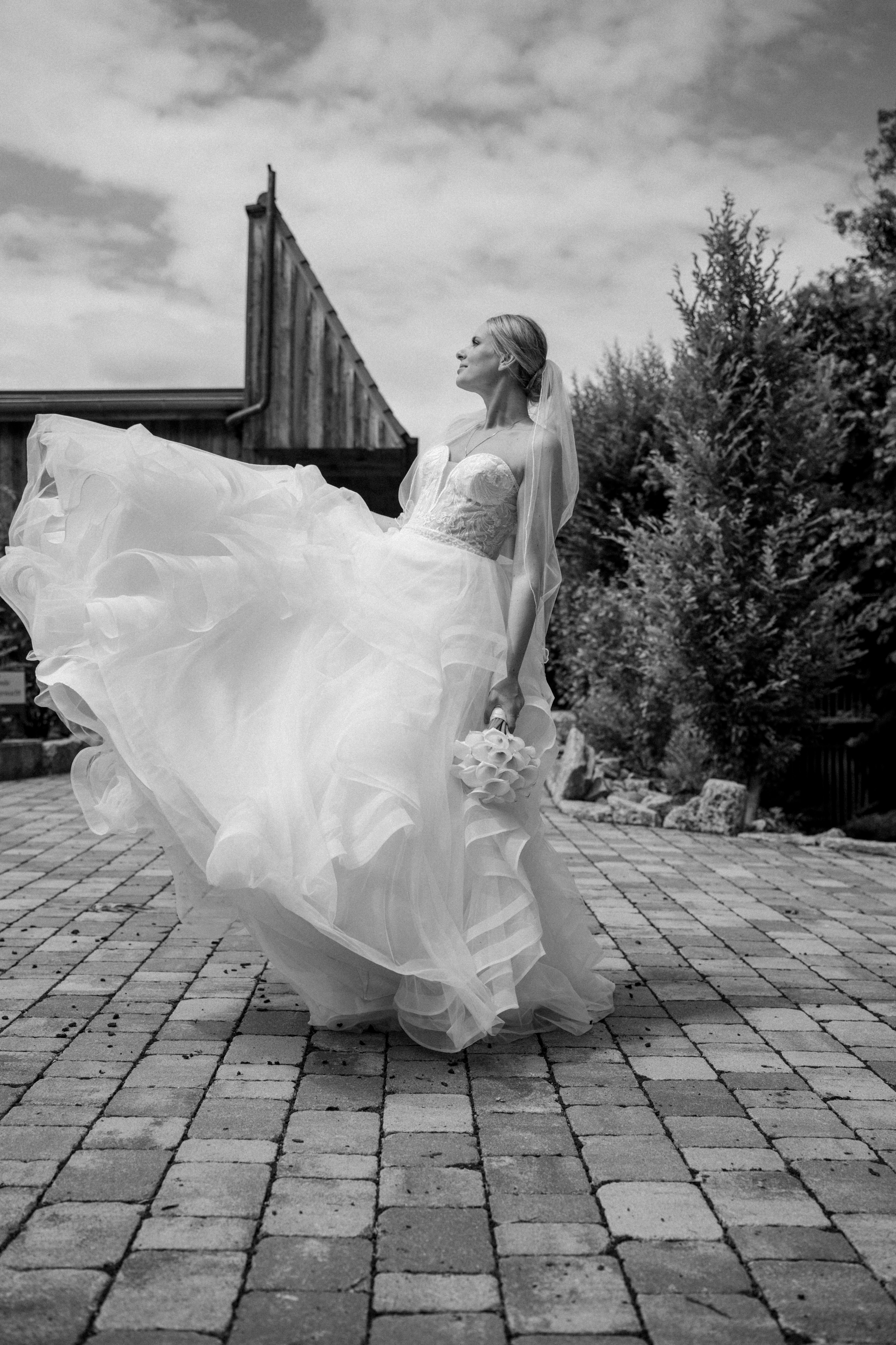 Braut im Kleid auf gepflastertem Platz im Freien