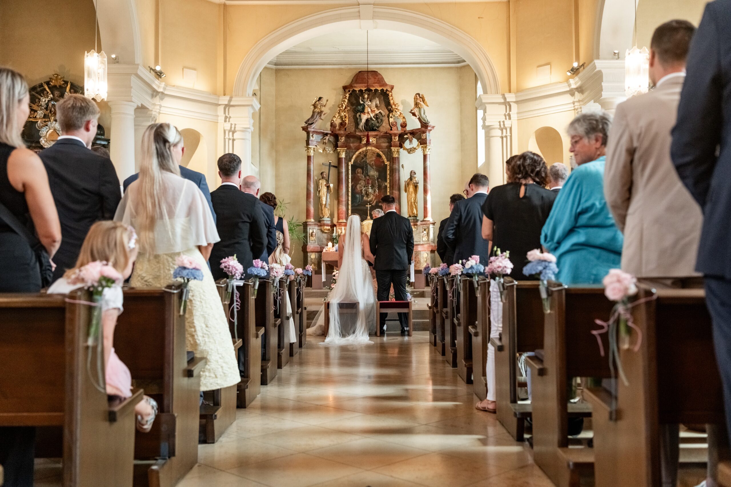 Kirchliche Trauung mit Brautpaar und Gästen