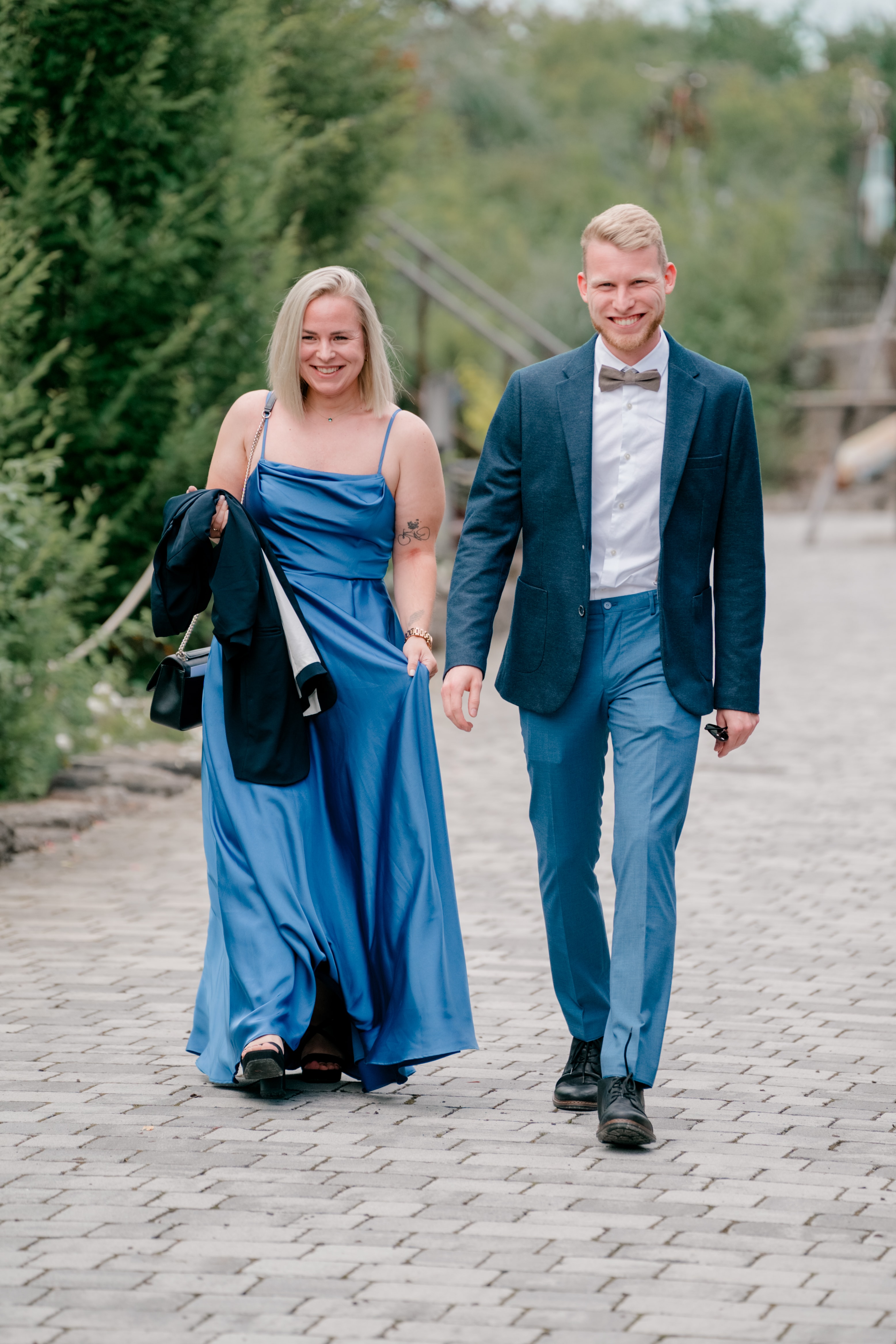 Gästepaar spaziert Hand in Hand im Gartenweg