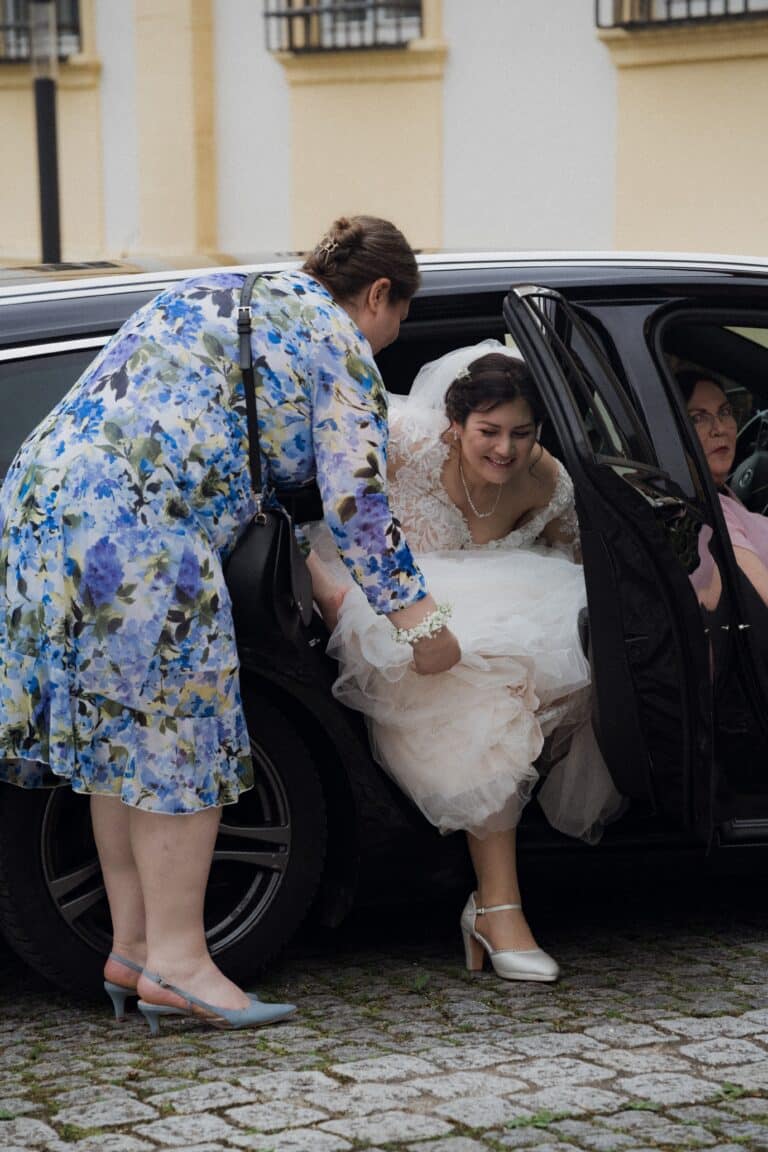 00276-florian-knusper-hochzeitsfotograf-wuerzburg-braut-steigt-aus-auto-Schloss Oberschwarzach