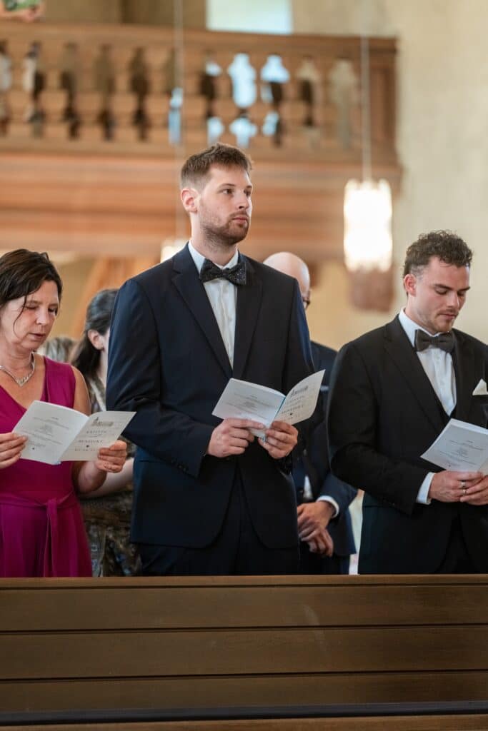 Gäste singen in der Kirche während Trauung