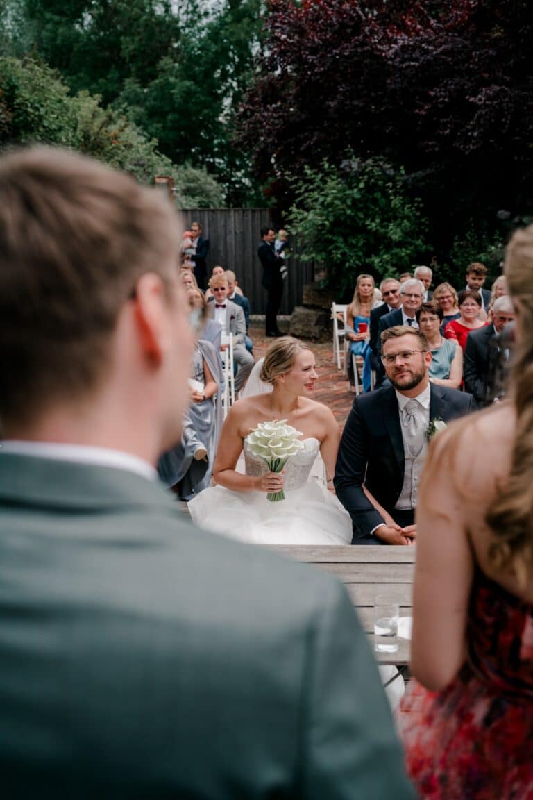 00337-florian-knusper-hochzeitsfotograf-wuerzburg-brautpaar-mit-gaesten-im-garten-Brückenbaron