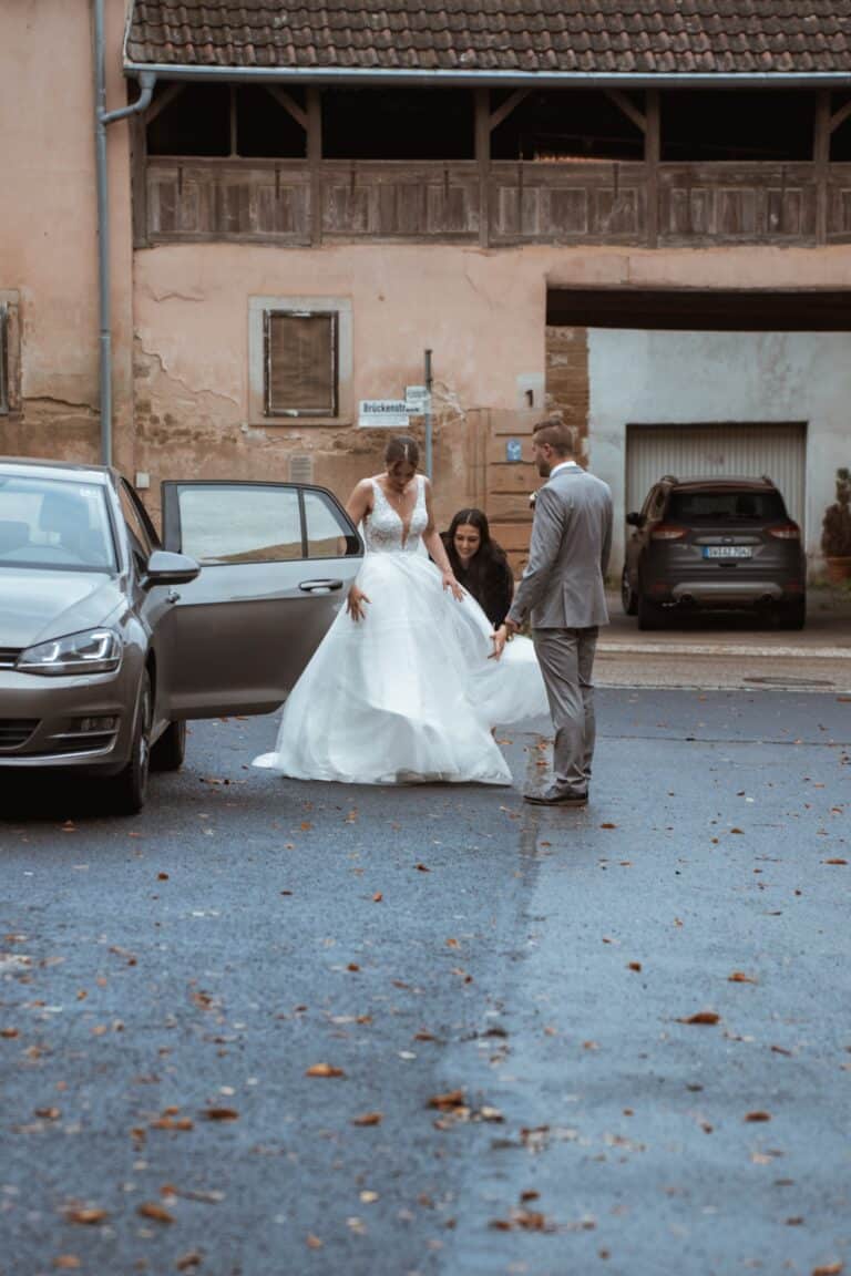 00351-florian-knusper-hochzeitsfotograf-wuerzburg-brautpaar-vor-auto-Schloss Zeilitzheim