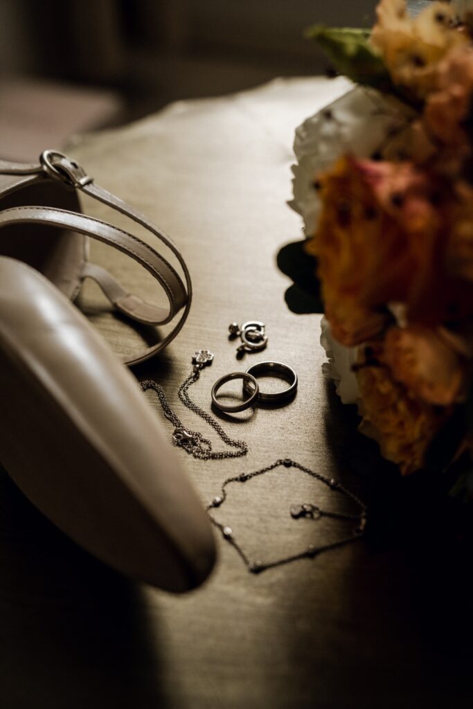 Brautaccessoires und Eheringe auf Holztisch