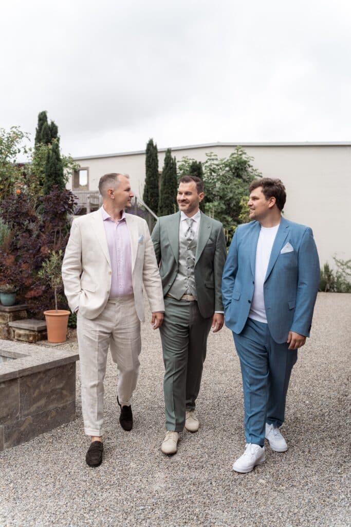 Gäste in eleganten Anzügen im Garten.