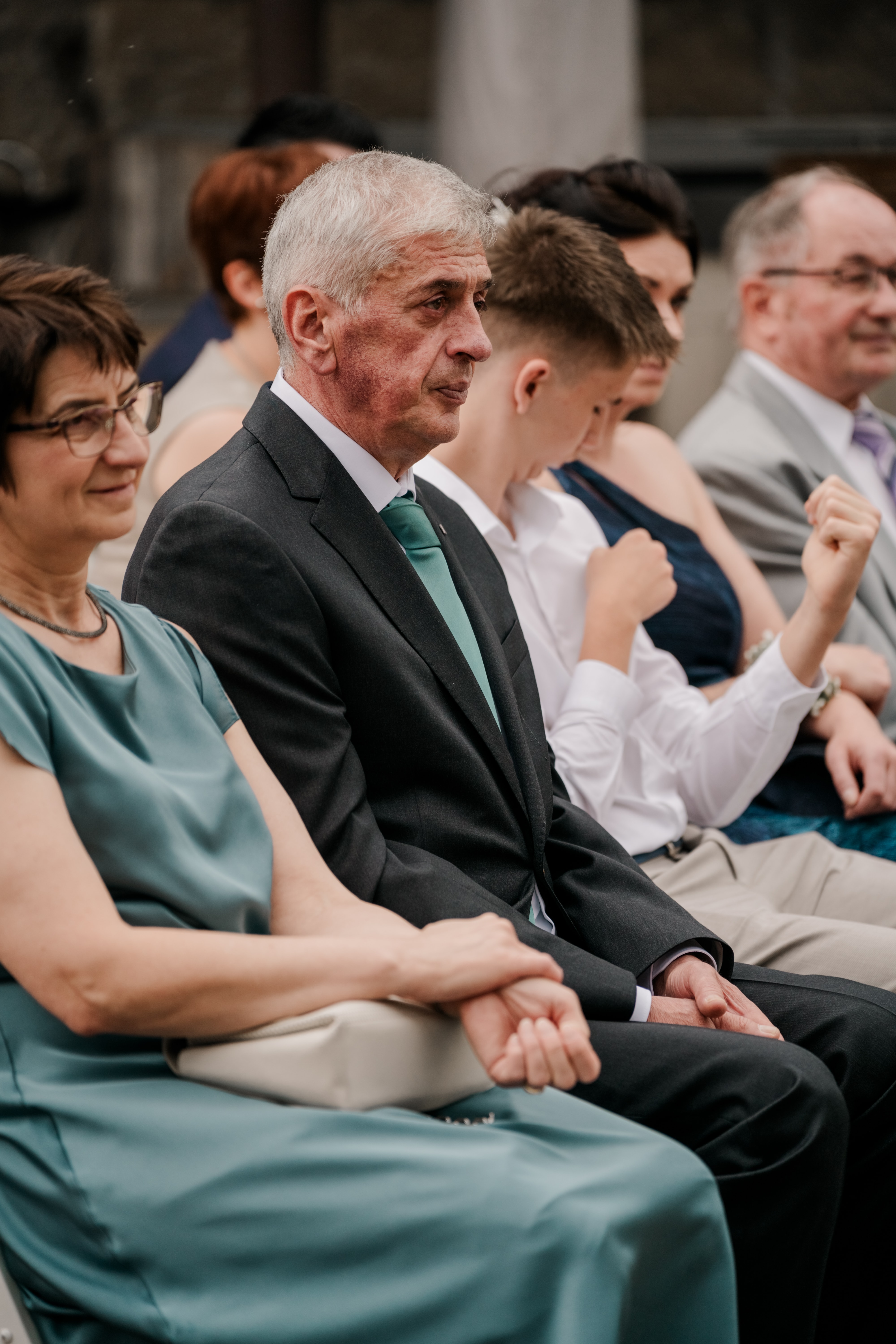 Gäste auf Hochzeitsfeier in eleganter Kleidung.