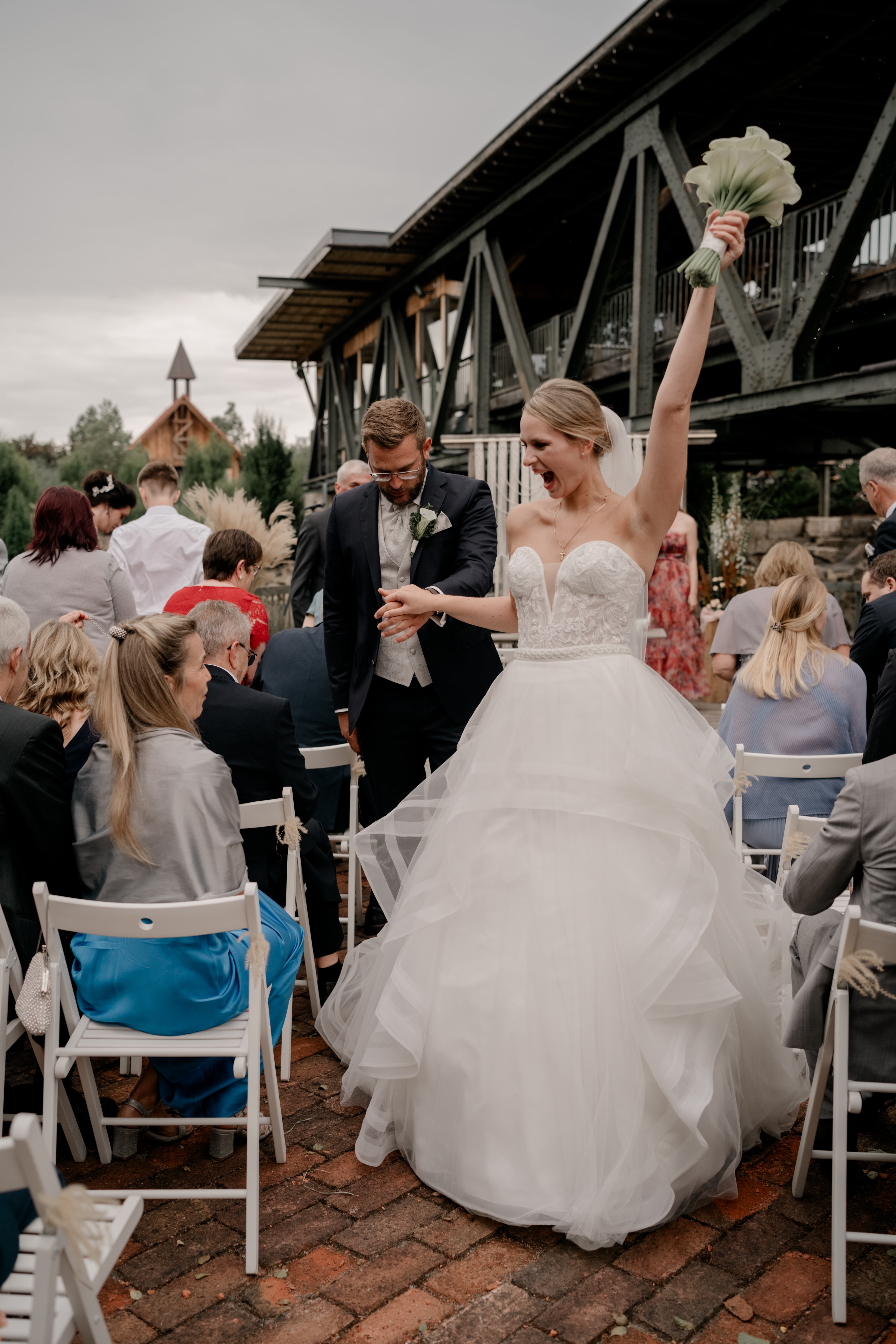 Brautpaar feiert draußen vor Hochzeitsgästen