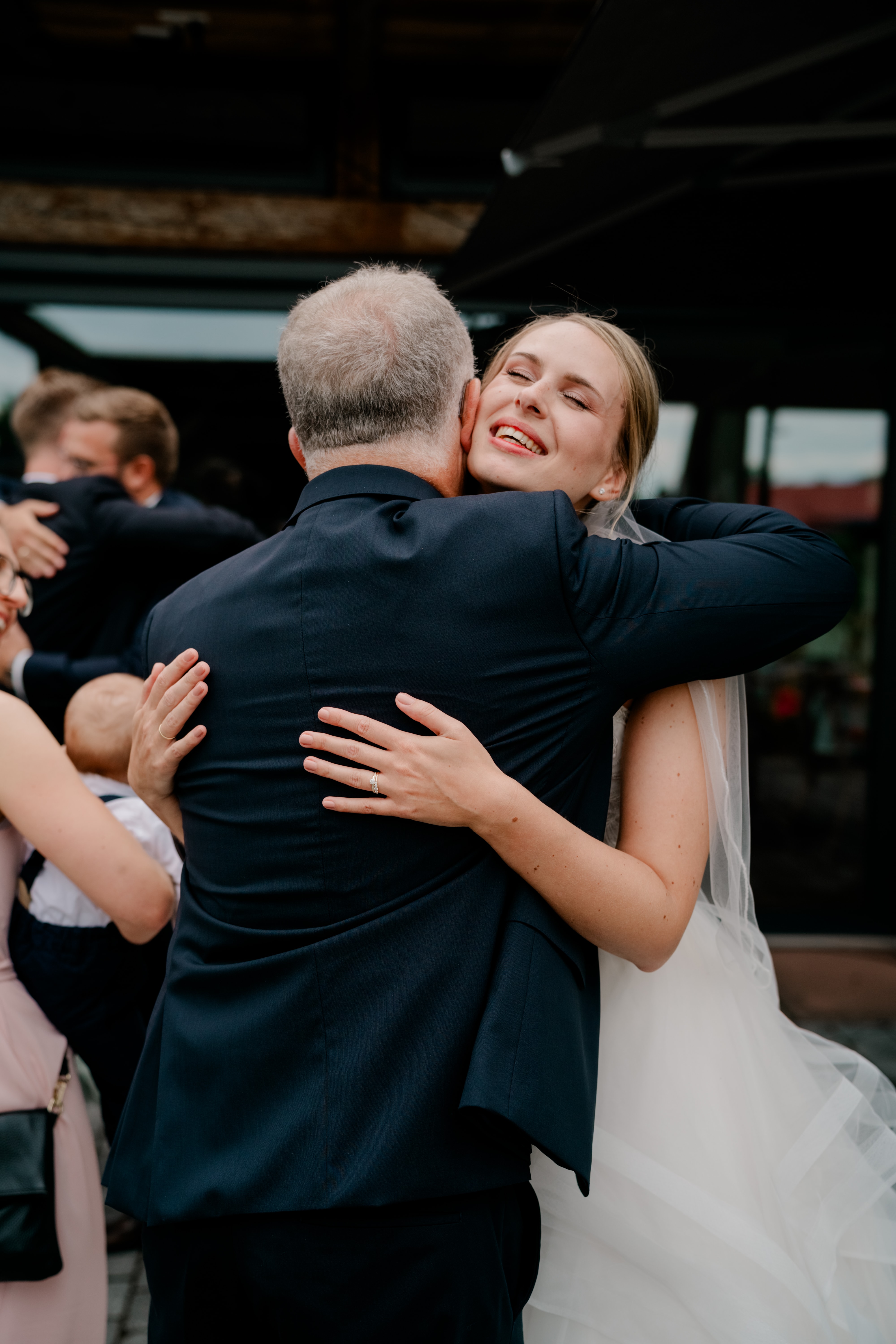 Braut umarmt Gast bei Hochzeitsfeier im Freien