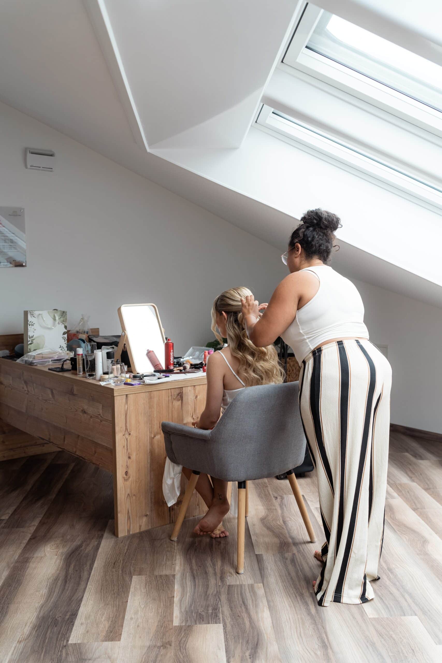 Braut beim Haarstyling im Ankleidezimmer