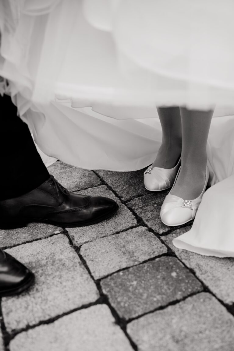 00490-florian-knusper-hochzeitsfotograf-wuerzburg-brautpaar-fuesse-pflastersteine-Brückenbaron