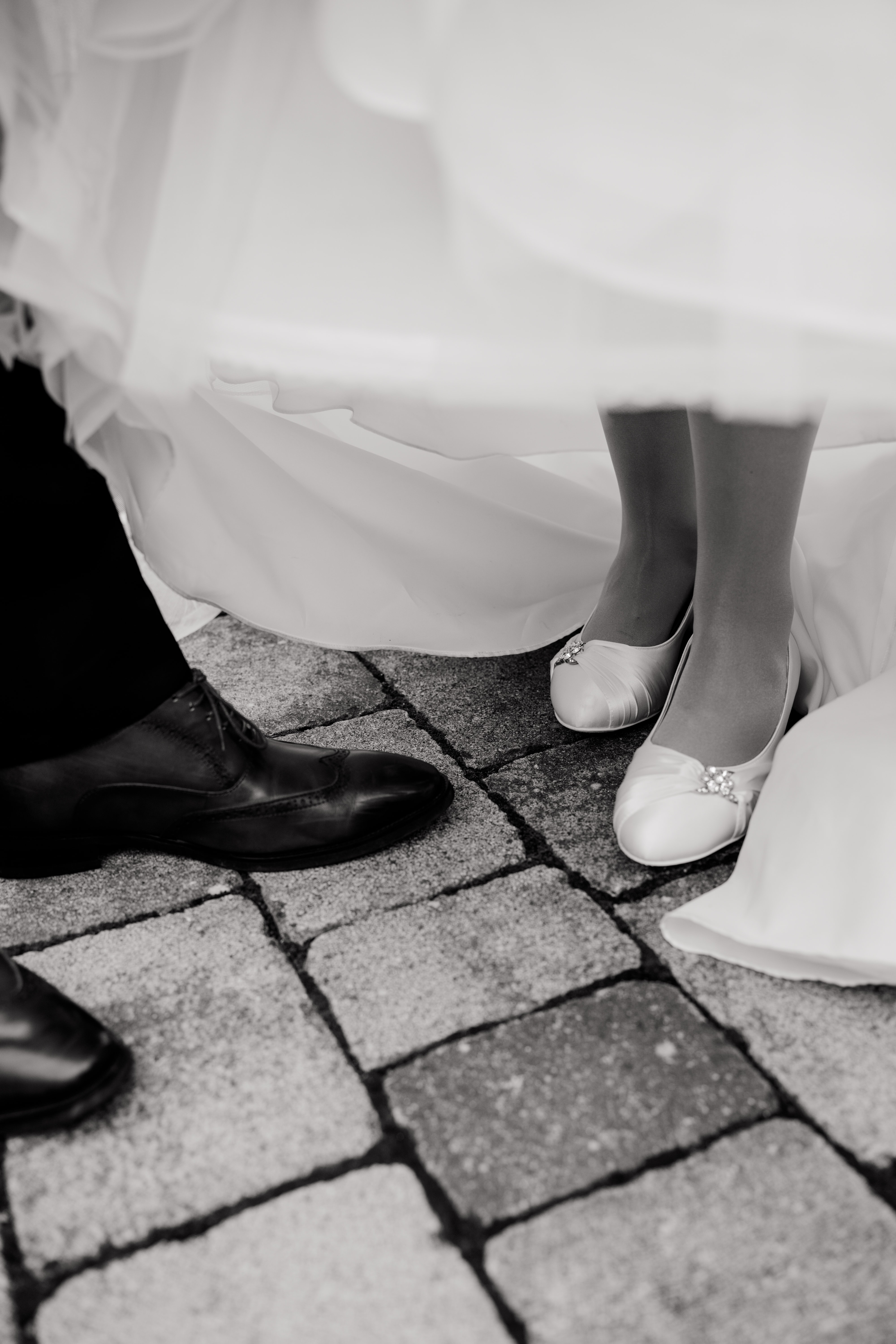 Brautpaar-Schuhe auf Kopfsteinpflaster