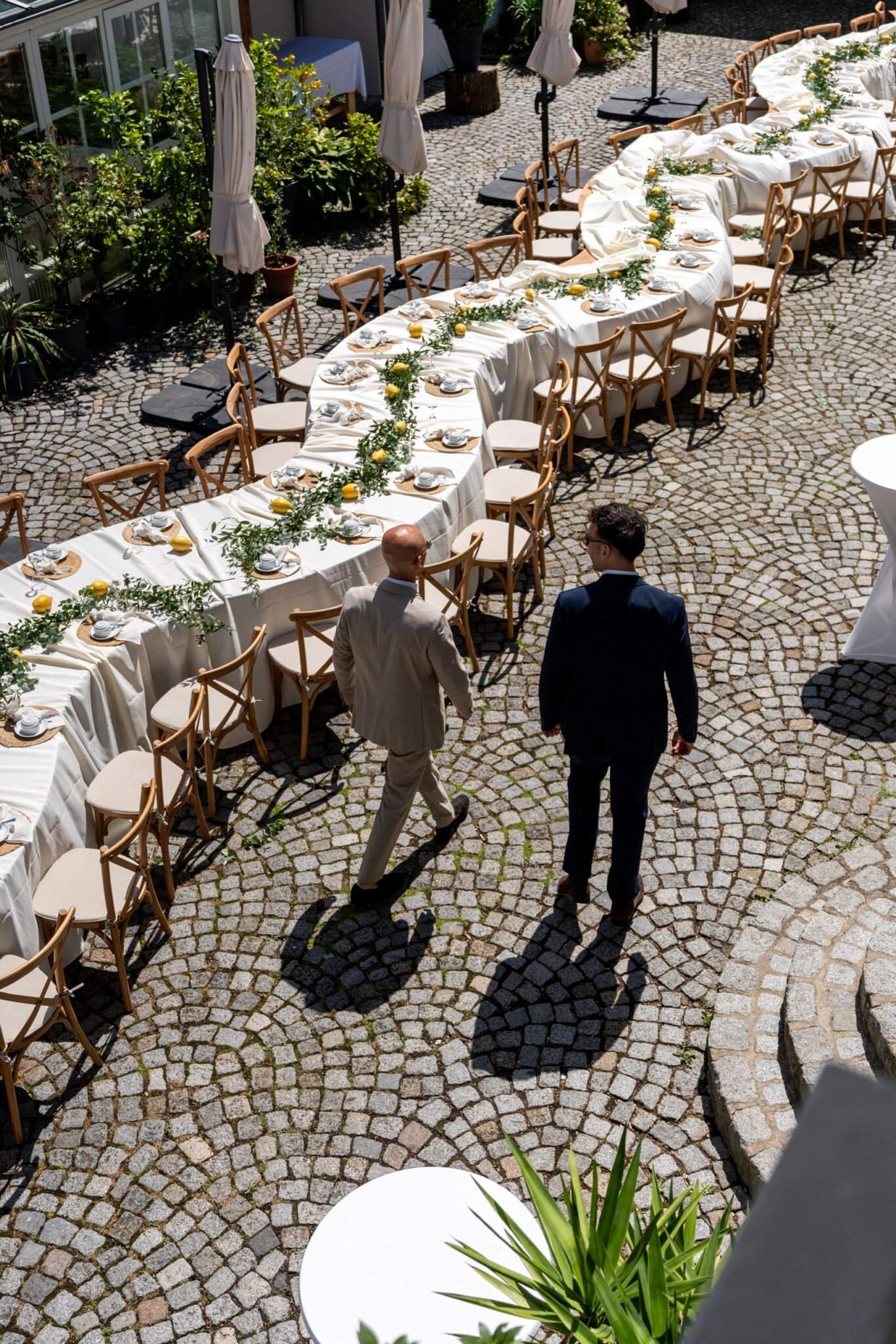 S-förmige Hochzeitstafel im Hof mit Zitronen und Grün