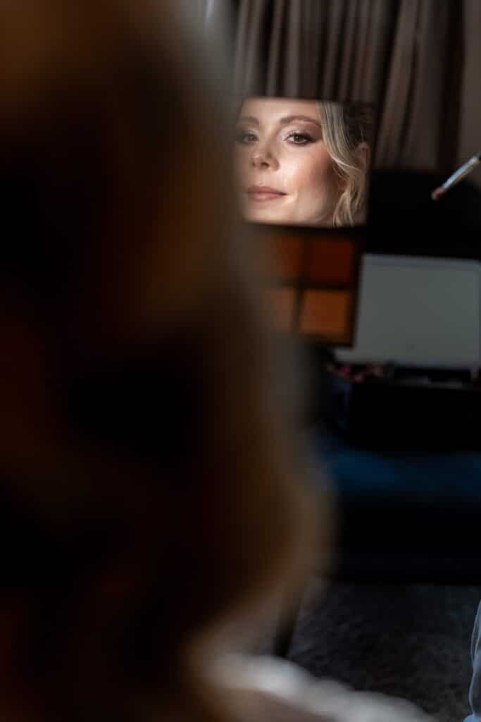 Braut macht Make-up mit Spiegel im Hintergrund