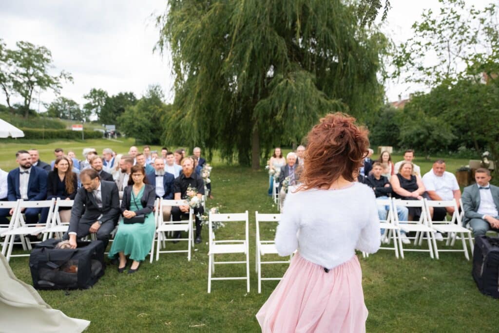 Gartenhochzeit mit sitzenden Gästen und Baumkulisse