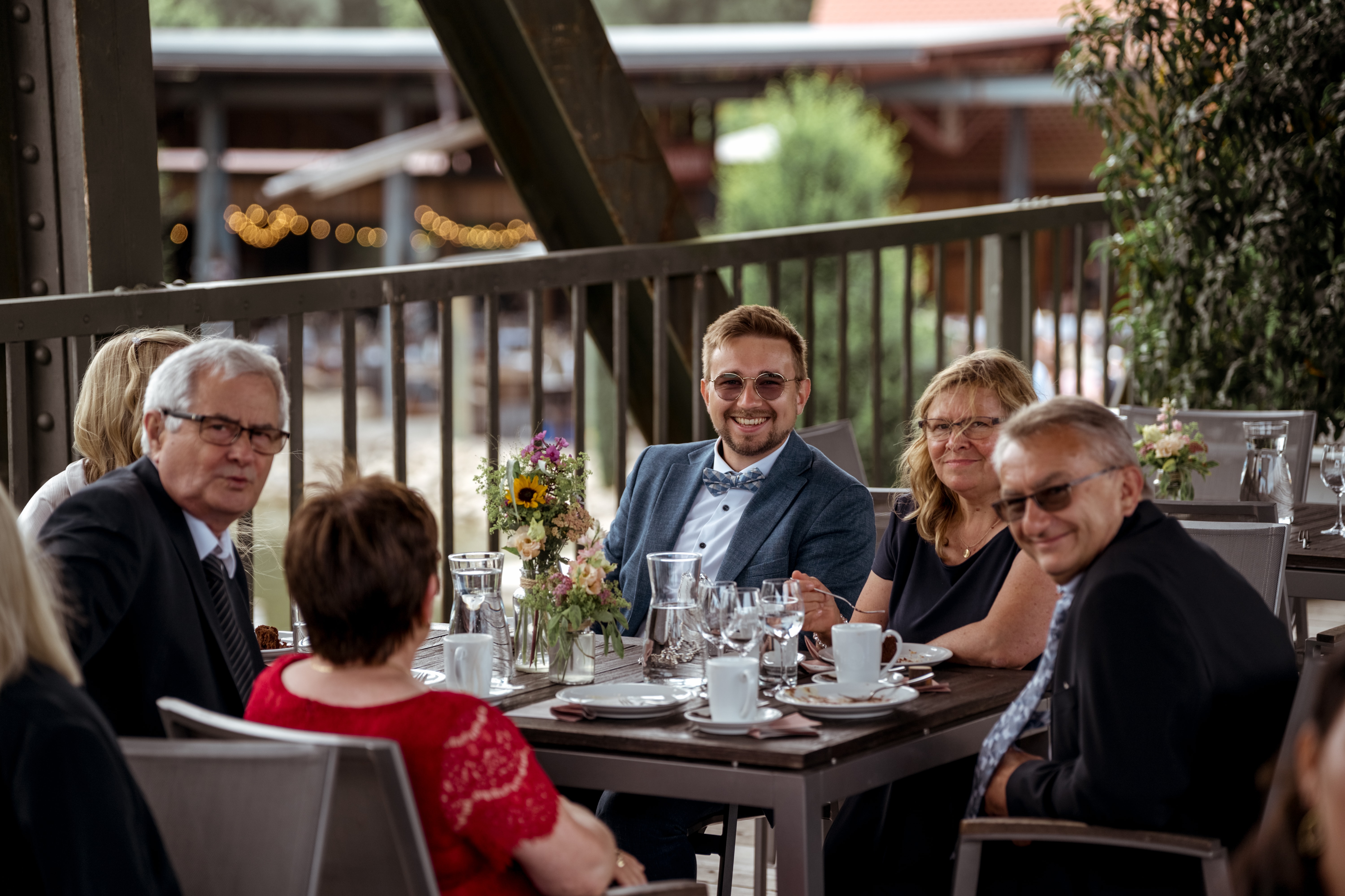 Gäste bei der Hochzeitsfeier an gedecktem Tisch.