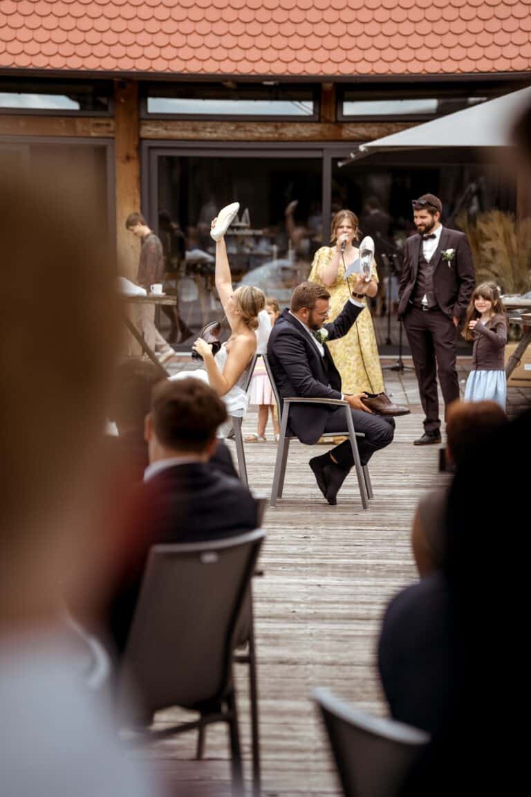 00574-florian-knusper-hochzeitsfotograf-wuerzburg-paar-mit-gaesten-auf-terrasse-Brückenbaron