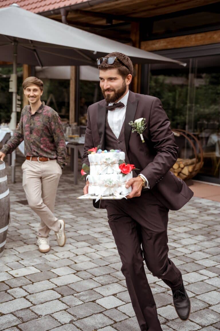 00579-florian-knusper-hochzeitsfotograf-wuerzburg-mann-mit-hochzeitstorte-Brückenbaron