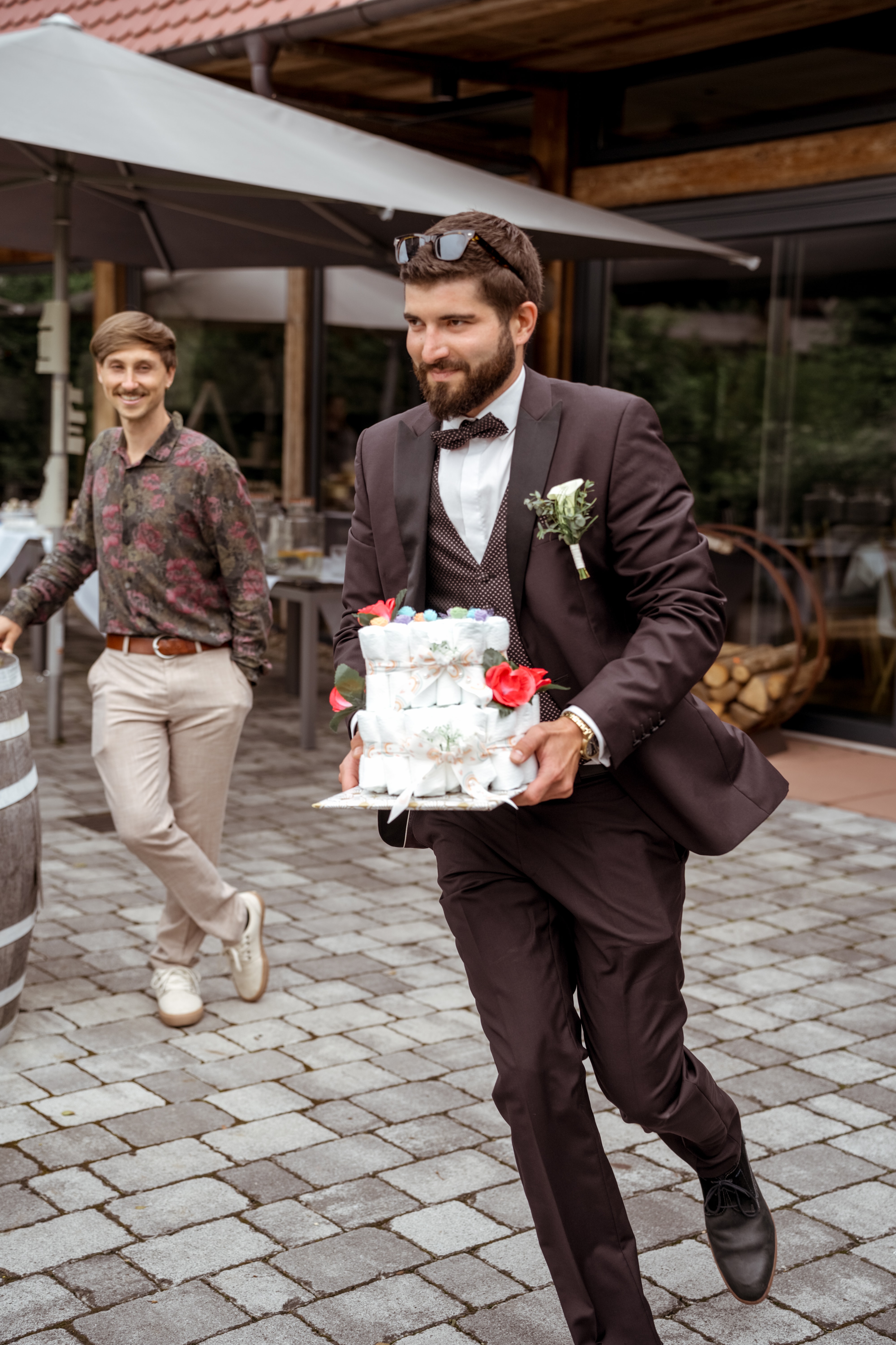 Hochzeitsgast trägt Torte im Freien