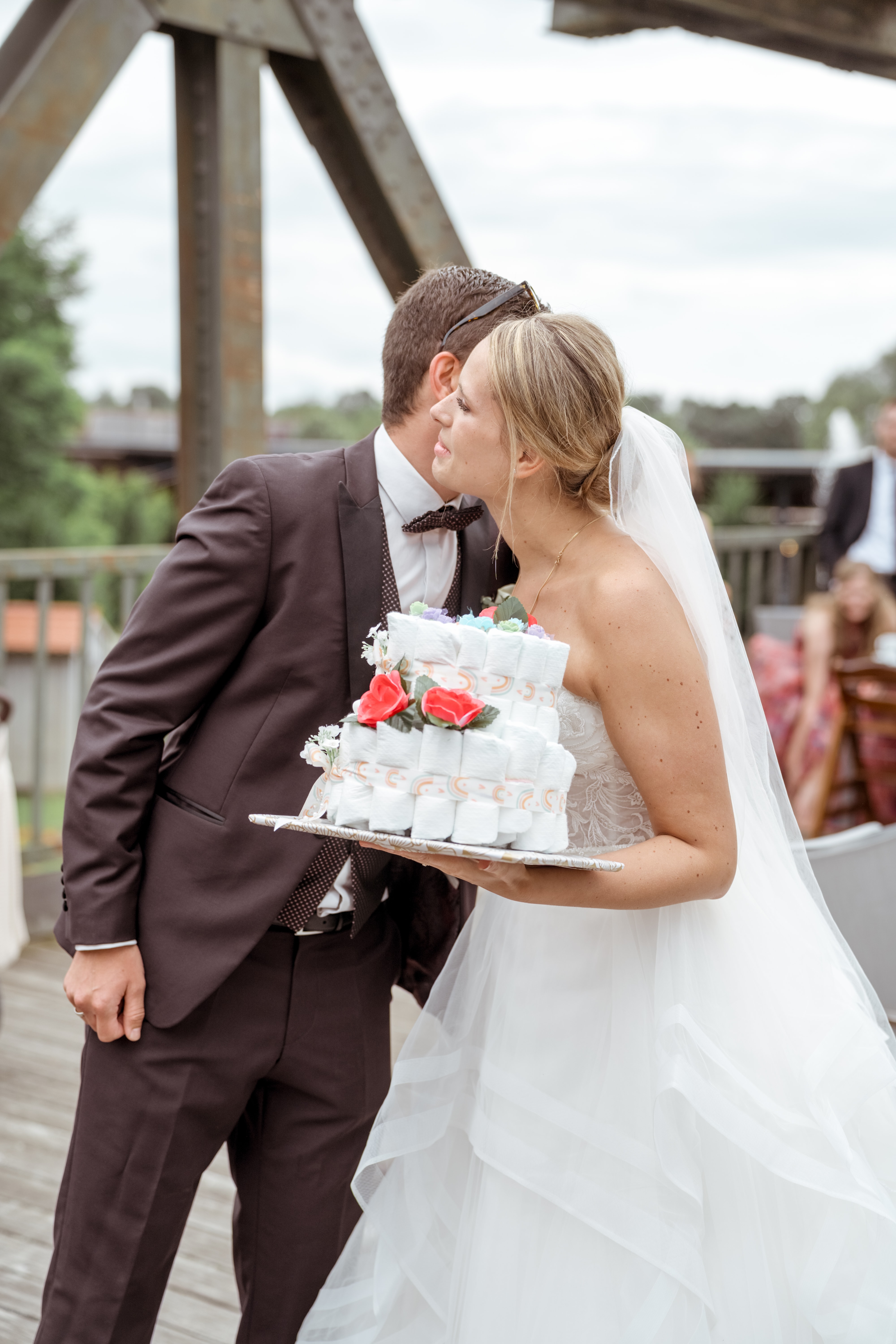 Brautpaar mit Windeltorte auf Holzterrasse