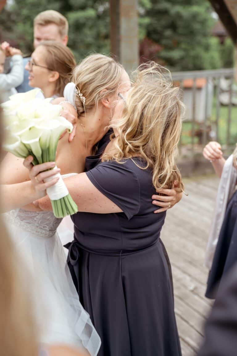 00588-florian-knusper-hochzeitsfotograf-wuerzburg-braut-umarmung-mit-gast-Brückenbaron