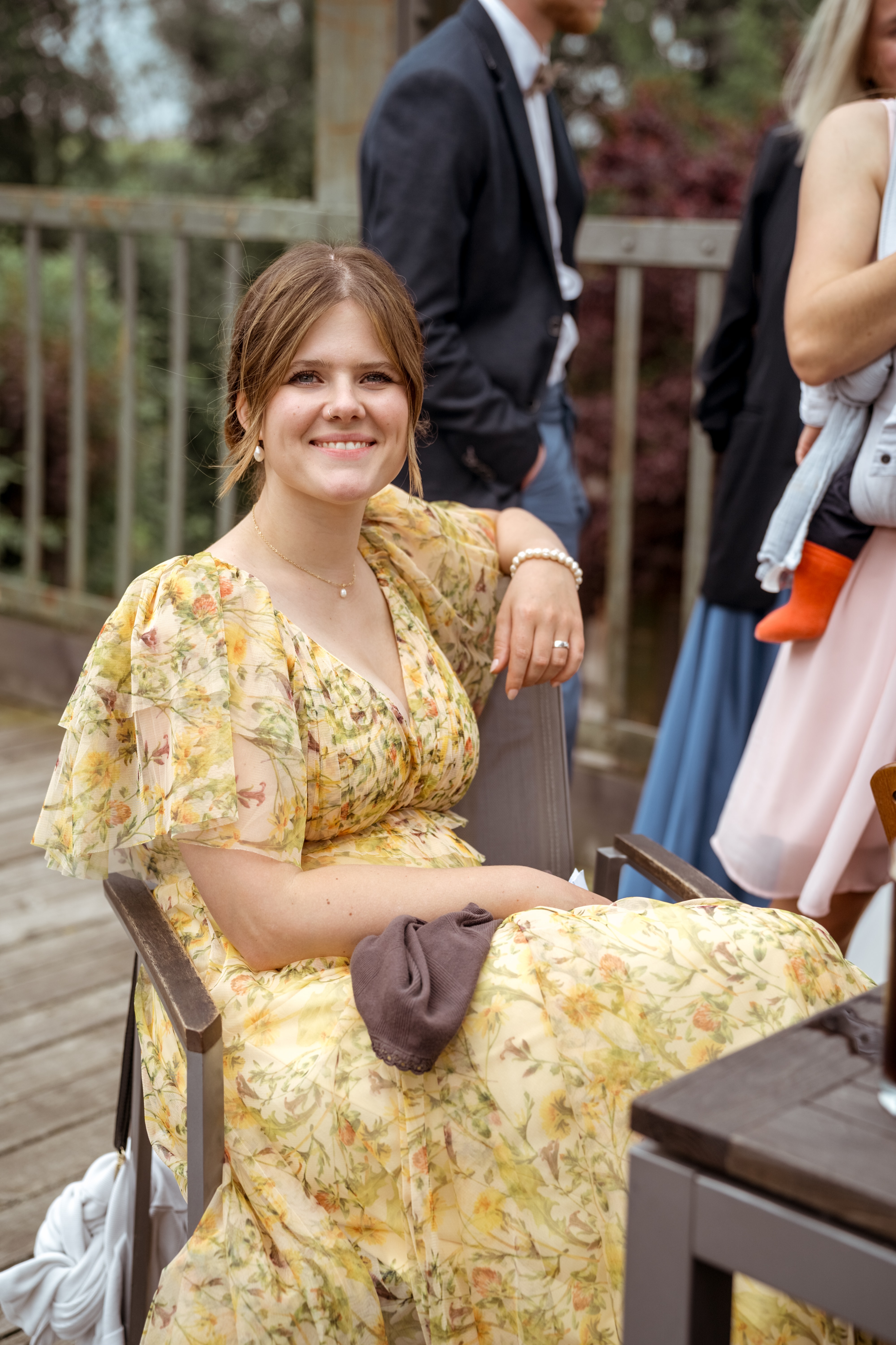 Gäste im Garten mit Blumenkleid und Anzug