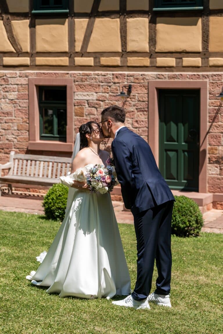 00619-florian-knusper-hochzeitsfotograf-wuerzburg-brautpaar-vor-fachwerkhaus-hofgut hünnersdorf