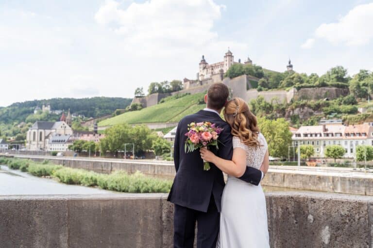 00709-florian-knusper-hochzeitsfotograf-wuerzburg-brautpaar-vor-burgansicht-Schlosshotel Steinburg Wuerzburg