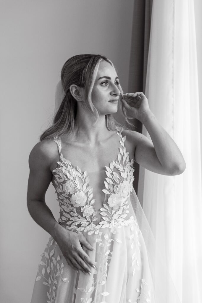 Braut im Hochzeitskleid am Fenster